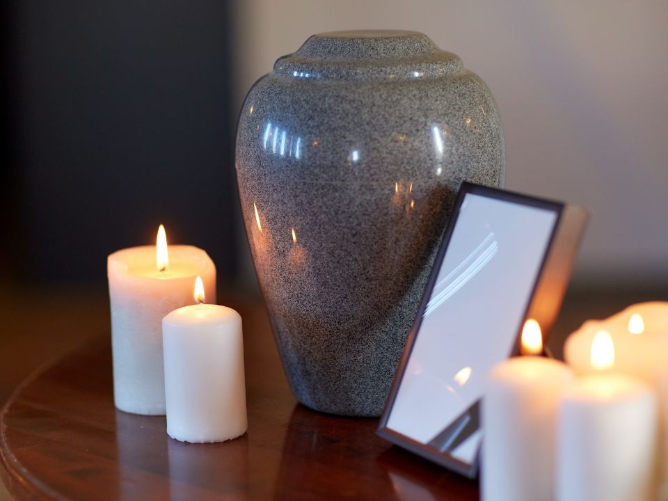 A gray urn surrounded by candles